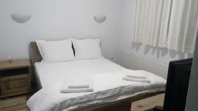 a white bed with white sheets and towels on it at Guesthouse White Margarit in Melnik