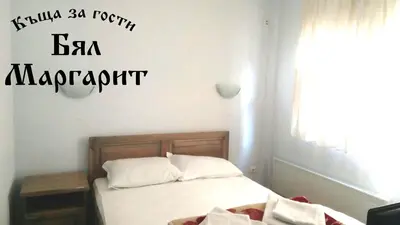 a bedroom with a bed with the words la marriott on the wall at Guesthouse White Margarit in Melnik