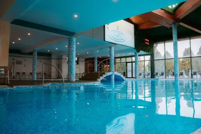 a large swimming pool in a hotel with blue ceilings at SPA Hotel Olymp in Velingrad
