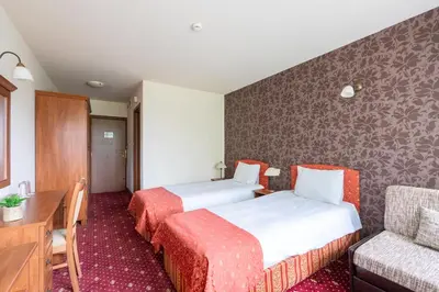 a hotel room with two beds and a couch at Hotel Hadjiite in Koprivshtitsa