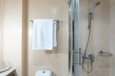 a bathroom with a shower with a toilet and a towel at Hotel Hadjiite in Koprivshtitsa