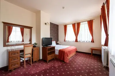 a hotel room with a bed and a television at Hotel Hadjiite in Koprivshtitsa
