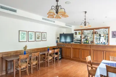 a dining room with a table and chairs and a tv at Hotel Hadjiite in Koprivshtitsa
