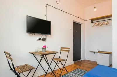 a living room with a table and a tv on a wall at Generaator Sofia in Sofia