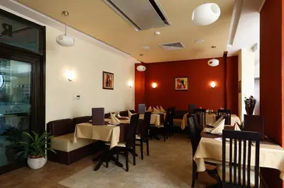 a restaurant with tables and chairs in a room at Evridika Hotel in Devin