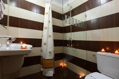 a bathroom with a sink and a toilet and candles at Evridika Hotel in Devin
