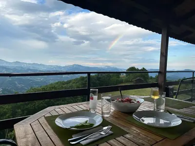 a table with two plates of food on a table with a view at Karadzhovata Kashta in Zlatograd