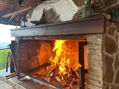 a brick oven with a fire in it at Karadzhovata Kashta in Zlatograd