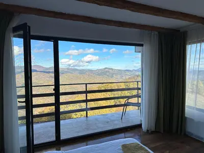 a bedroom with a large window with a view at Karadzhovata Kashta in Zlatograd