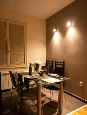 a dining room with a table and chairs with flowers on it at Sunny Central Apartment in Sofia