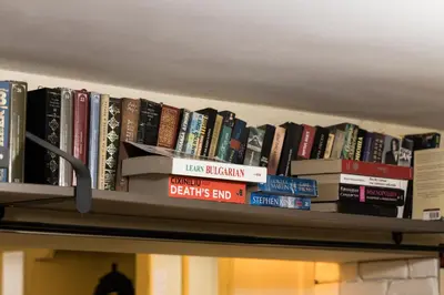 a row of books on a shelf in a library at Vintage Lozenets Apartment in Sofia