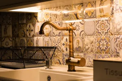 a bathroom with a faucet next to a bench at Vintage Lozenets Apartment in Sofia