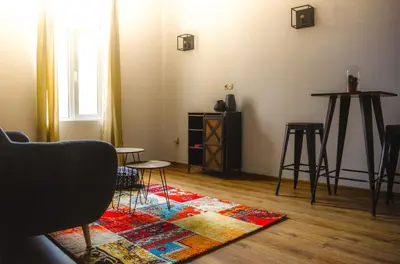 a living room with a table and chairs and a rug at The Dutchies' apartment in Plovdiv
