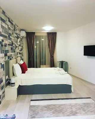 a bedroom with a large white bed with red pillows at Apartments Park Place in Sandanski