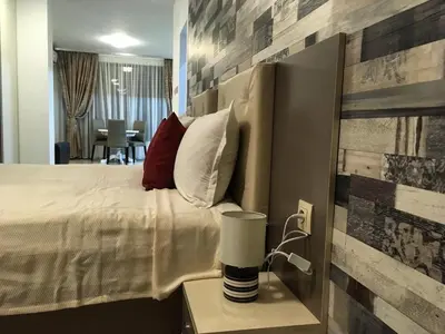 a bedroom with a bed and a table with a lamp at Apartments Park Place in Sandanski