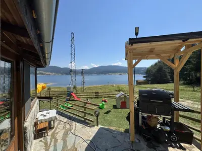 a backyard with a grill and a view of the water at Villa Raiski kyt in Dospat