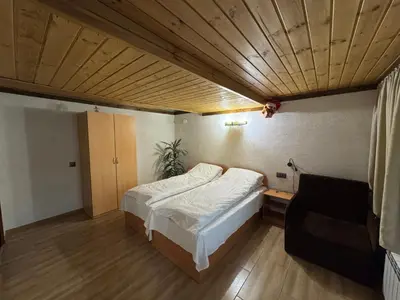 a bedroom with a bed and a couch in it at Villa Raiski kyt in Dospat
