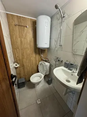 a small bathroom with a toilet and a sink at Villa Raiski kyt in Dospat