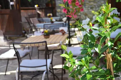 a group of tables and chairs on a patio at Family Hotel Dinchova kushta in Rozhen