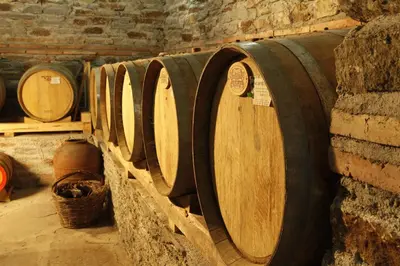 a row of wooden barrels in a room at Family Hotel Dinchova kushta in Rozhen