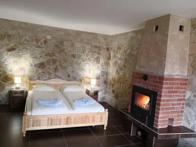 a bedroom with a bed and a brick fireplace at Yurukovata kashta in Koprivshtitsa