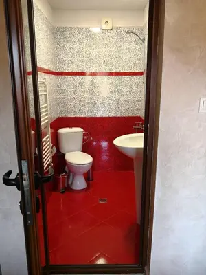 a red bathroom with a toilet and a sink at Yurukovata kashta in Koprivshtitsa