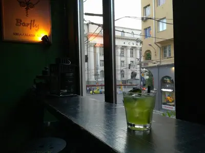 a drink sitting on top of a bar with a window at Interhost Guest rooms and apartments in Sofia