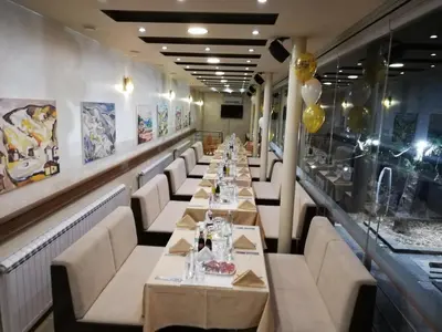 a long dining room with long tables and white chairs at Heat Complex Family Hotel in Peshtera