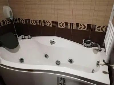 a white bath tub in a small bathroom at Heat Complex Family Hotel in Peshtera