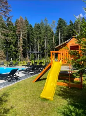 a playground with a slide next to a house at Iglika Hotel & Villas Borovets in Borovets