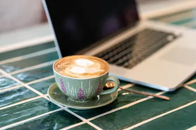 a cup of coffee on a table next to a laptop at Boutique Hotel Casa Art in Oreshak