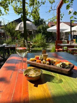 a wooden table with a plate of food and a glass of wine at Boutique Hotel Casa Art in Oreshak