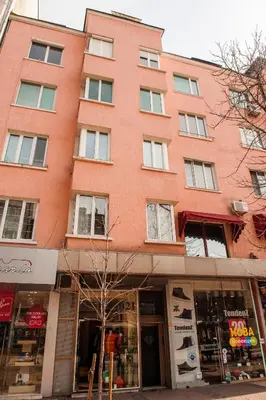 a large red brick building on a city street at Vitosha Blvd - Attic Studio in Sofia