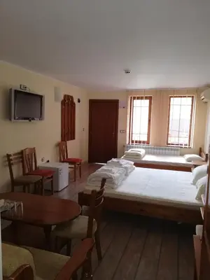 a large bed in a room with chairs and tables at Комплекс Рожена, хотел, хотелски комплекс Рожена in Rozhen