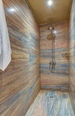 a bathroom with a shower with wooden walls at Shiroka Laka Hotel in Shiroka Lŭka