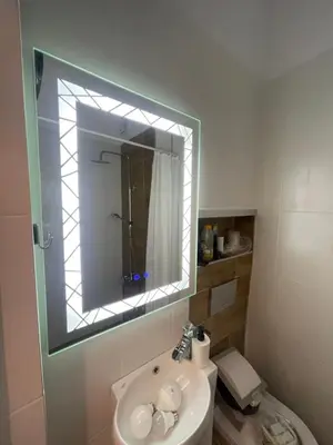 a bathroom with a sink and a mirror over a toilet at Top center 
