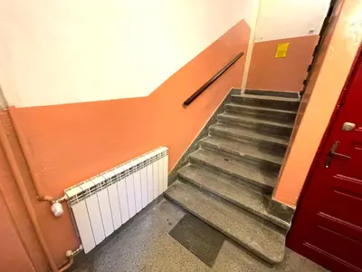 a staircase in a building with a red door at Top center 