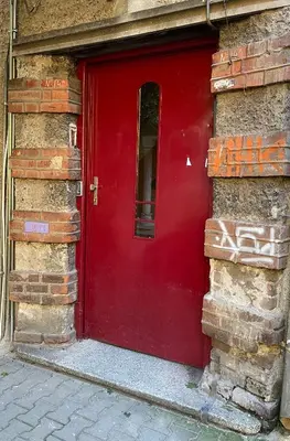a red door on the side of a building at Top center 