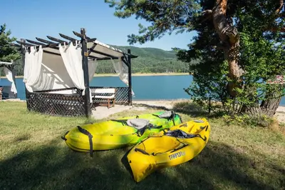 two kayaks sitting on the grass next to a gazebo at Family Hotel Hebar in Batak