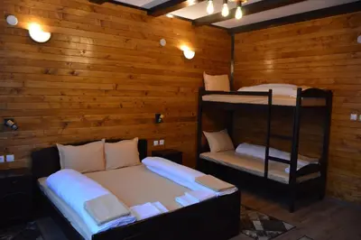 two bunk beds in a room with wooden walls at Ваканционно селище Ива in Sarnitsa