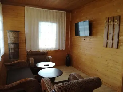 a room with chairs and a table and a television at Ваканционно селище Ива in Sarnitsa