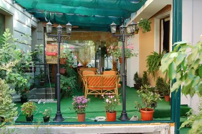 a porch with a table and chairs and potted plants at Kniaz Boris Hotel in Sofia