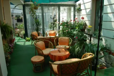 a balcony with chairs and a table and flowers at Kniaz Boris Hotel in Sofia