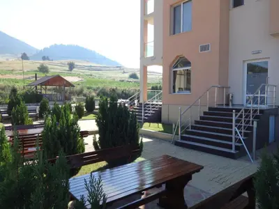 a building with stairs and benches in front of a building at Семеен хотел 