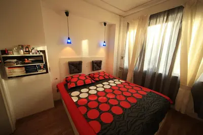 a bedroom with a bed with a red and black blanket at Cozy Flat in Sofia