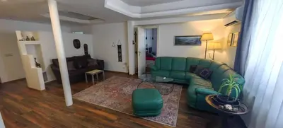 a living room with a green couch and a table at Cozy Flat in Sofia