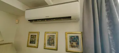 a wall with four pictures and a flat screen tv at Cozy Flat in Sofia