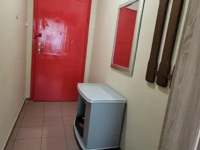 a red door in a bathroom with a trash can at Cozy apartment in the heart of Sofia in Sofia