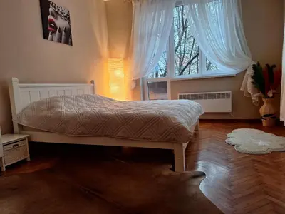 a bedroom with a bed and a large window at Cozy apartment in the heart of Sofia in Sofia
