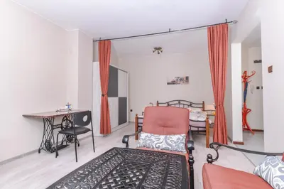 a living room with a chair and a table at Visit Sofia Macedonia Square Central Apartment by Flat Mаnager in Sofia